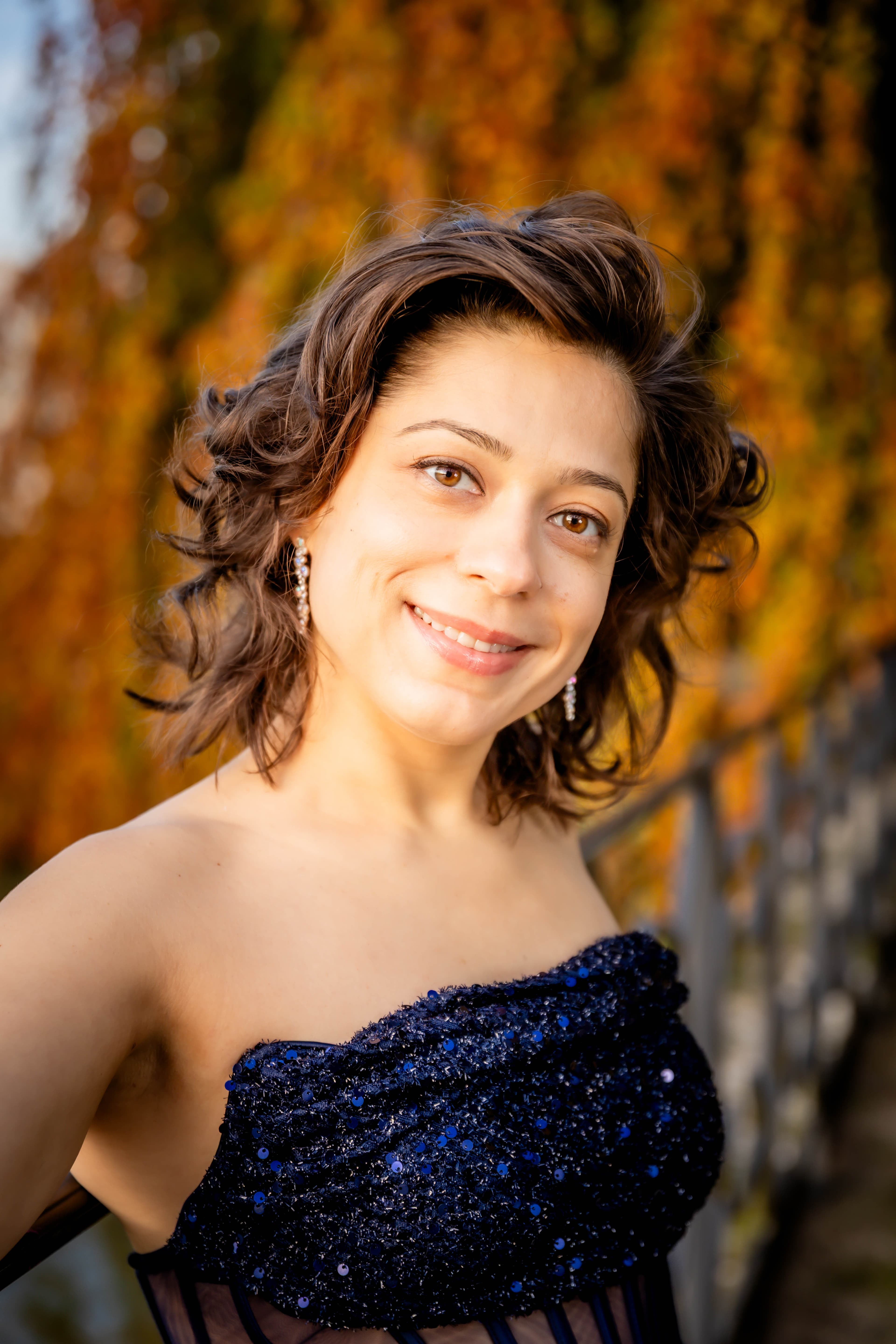 Maria Muraeva souriant en automne, robe bleue scintillante